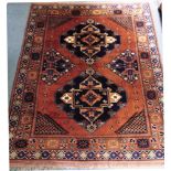 A LARGE RED GROUND RUG the central field with two main medallions, within decorative borders,