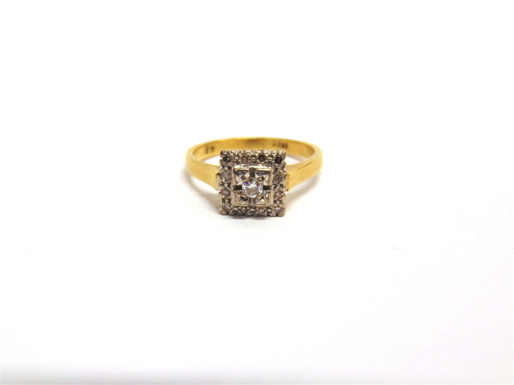 A DIAMOND CLUSTER RING stamped '18ct', the central brilliant cut enclosed by twelve single cuts,