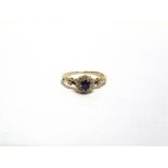 A SAPPHIRE AND DIAMOND CLUSTER RING the yellow split shoulder shank stamped '18ct' and 'H&Co', the