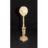 A CHINESE IVORY PUZZLE BALL ON STAND late 19th or early 20th century, the dragon entwined outer ball