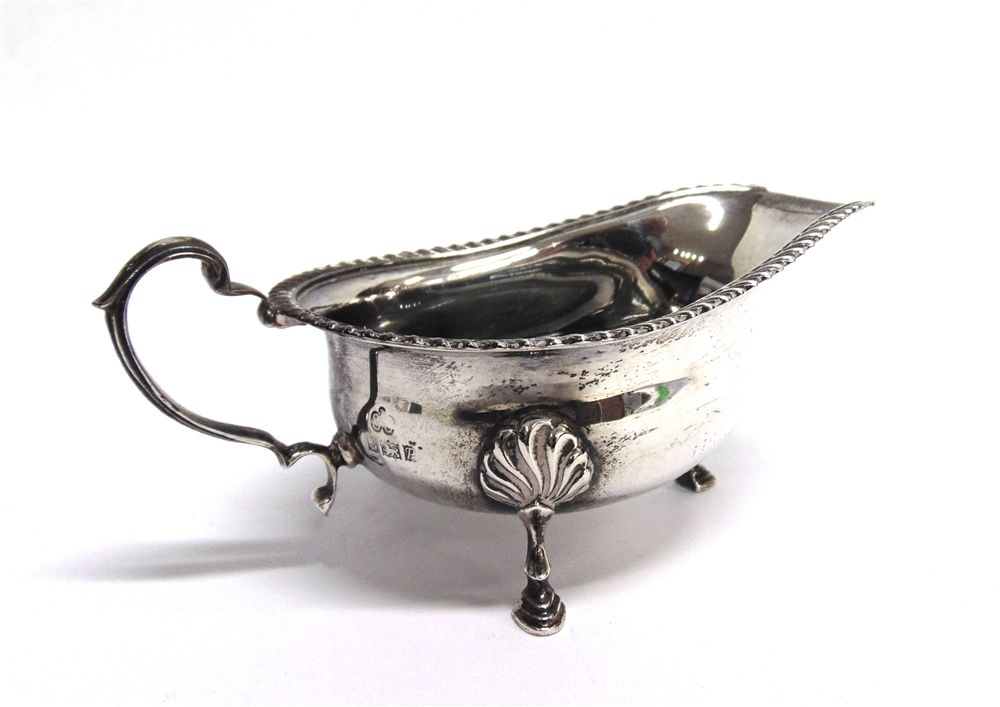 A SILVER SAUCEBOAT by Elkington & Co, Birmingham 1964, with gadrooned rim, scroll handle and on