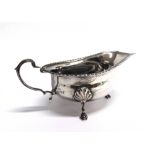 A SILVER SAUCEBOAT by Elkington & Co, Birmingham 1964, with gadrooned rim, scroll handle and on
