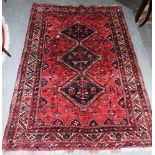 A RED GROUND RUG with triple pole medallion, 240cm x 170cm