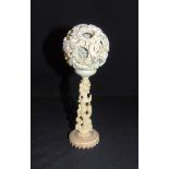 A CHINESE IVORY PUZZLE BALL ON STAND late 19th or early 20th century, the dragon entwined outer ball