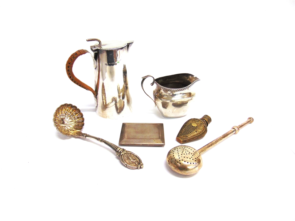 A LATE VICTORIAN SMALL SILVER HOT WATER JUG a silver cream jug; a silver book of matches case;