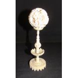 A CHINESE IVORY PUZZLE BALL ON STAND late 19th or early 20th century, the dragon entwined outer ball