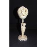 A CHINESE IVORY PUZZLE BALL ON STAND late 19th or early 20th century, the dragon entwined outer ball