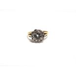 AN ELEVEN STONE DIAMOND CLUSTER RING unmarked, the central brilliant cut of approximately 0.85