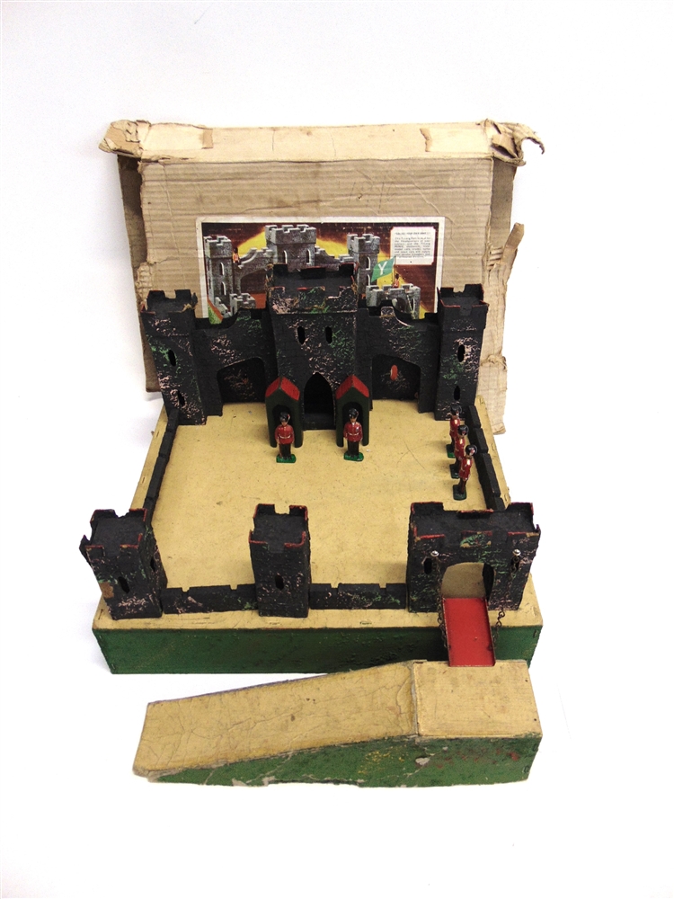 A TRI-ANG TOY FORT of painted wood and card construction, with five lead soldiers, boxed.