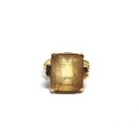 A CITRINE SINGLE STONE RING the rectangular step-cut stone claw set in yellow metal between