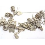 A MODERN SILVER CURB LINK 'CHARM' BRACELET on a padlock clasp, Birmingham 1992, hung with various
