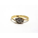 AN EARLY 20TH CENTURY GOLD AND TINY DIAMOND THREE STONE CROSS-OVER RING stamped '18ct', size P, 2.1g