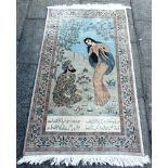 A PICTORIAL SILK RUG depicting a courting couple, above Arabic script, 93cm x 160cm