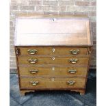 A PROVINCIAL OAK BUREAU with mahogany crossbanding, the interior fitted with pigeonholes and drawers