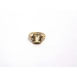 A 9CT GOLD AND CITRINE SINGLE STONE RING the emerald-cut stone rub-over set between split leaf