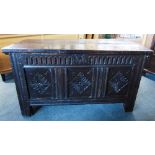 AN OAK COFFER the triple panel front carved with lozenges, 126cm wide 60cm deep 72cm high