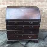 A PROVINCIAL OAK AND ELM BUREAU with two short and three long drawers on bracket feet, 93cm wide