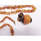 THREE AMBER NECKLACES with tumbled beads; with a large amber bead pendant with metal mounts; 157g