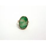 AN EARLY 20TH CENTURY GOLD AND JADEITE RING the oval panel pierced and carved with fruits and