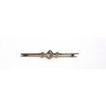 AN EARLY 20TH CENTURY GOLD AND DIAMOND THREE STONE BAR BROOCH the central cushion-shaped old-cut