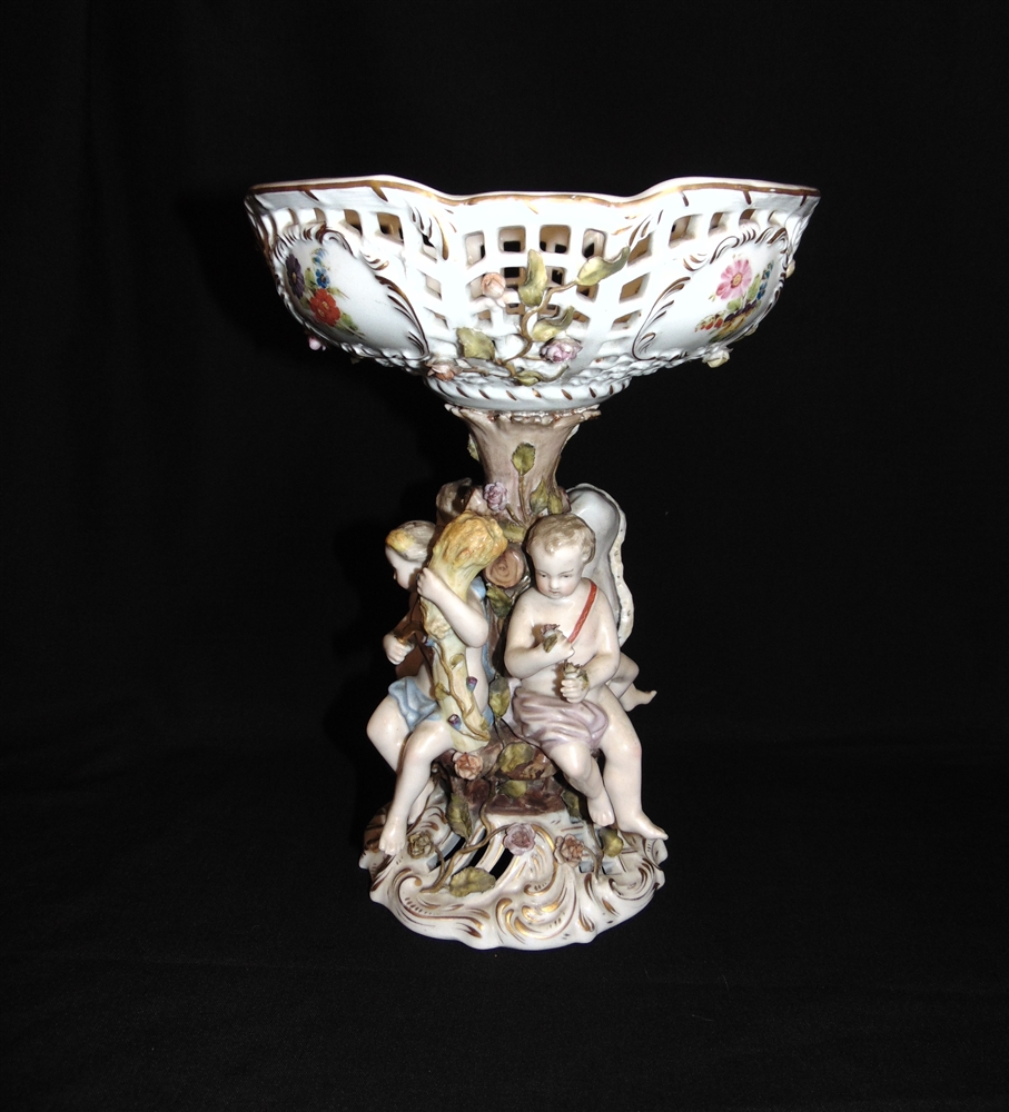 A CONTINENTAL SITZENDORF STYLE FIGURAL CENTREPIECE COMPORTE the pierced basket supported by four