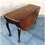 A MAHOGANY DROP-LEAF DINING TABLE on cabriole supports with pointed pad feet, the oval top 144cm x