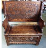 A CARVED OAK MONKS BENCH 92cm wide