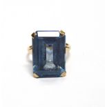 A 9CT GOLD AND BLUE SYNTHETIC SPINEL RING the rectangular step cut stone claw set on a 'D' section