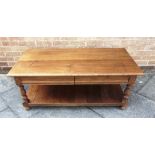 A REPRODUCTION OAK COFFEE TABLE the oblong top with moulded edge 60cm x 110cm, on turned supports