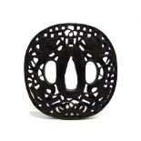 A JAPANESE IRON TSUBA probably Edo period, cast with two dragons chasing a flaming pearl,