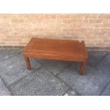 A CHINESE HARDWOOD LOW OCCASIONAL TABLE with carved decoration, the oblong top 45cm x 91cm