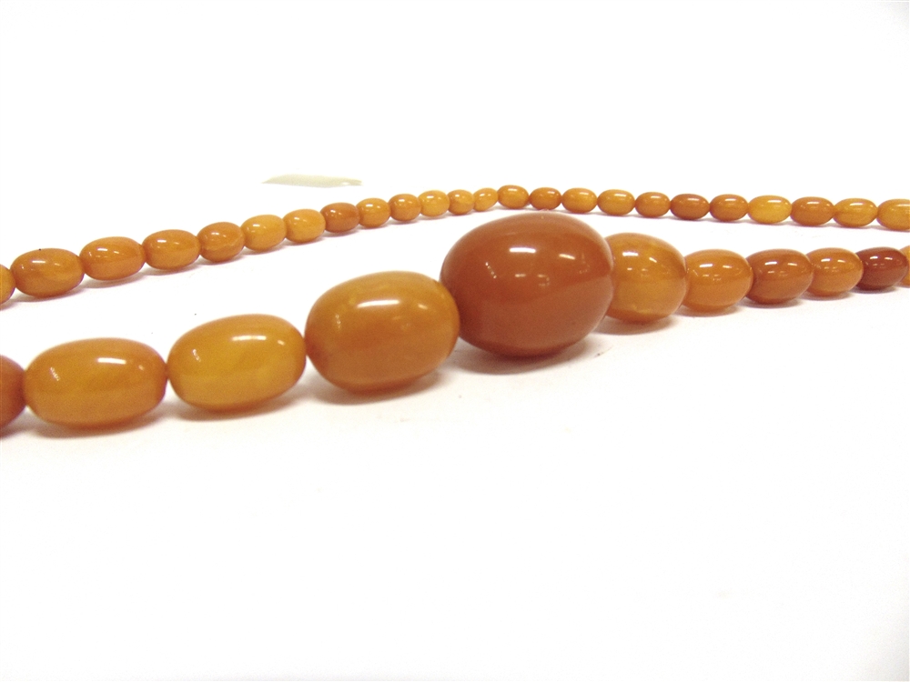 AN EARLY 20TH CENTURY AMBER NECKLACE the 50 oval beads graduated approx. 35mm X 26mm to 12 X 8mm, - Image 2 of 3