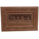 AN INDIAN HARDWOOD PANEL with intricate deep relief carved decoration depicting a seated deity and