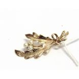 A 9CT GOLD AND CULTURED PEARL SPRAY BROOCH the two stylised oak(?) leaf stems tied with a ribbon bow