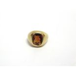 A MODERN OBLONG DOMED-TOP CITRINE SIGNET RING the burnt-orange stone rub-over set between tapering