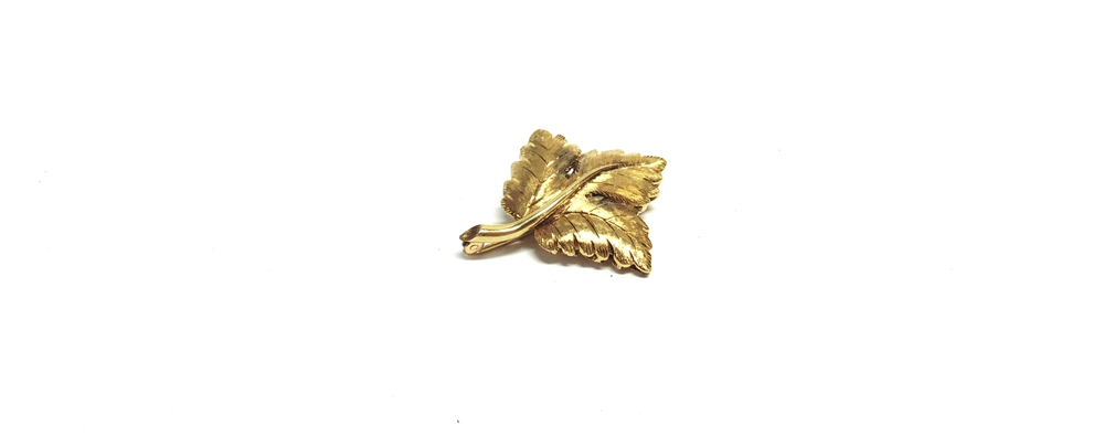 AN ITALIAN LEAF BROOCH in the form of three satinised leaves growing from a polished stem,