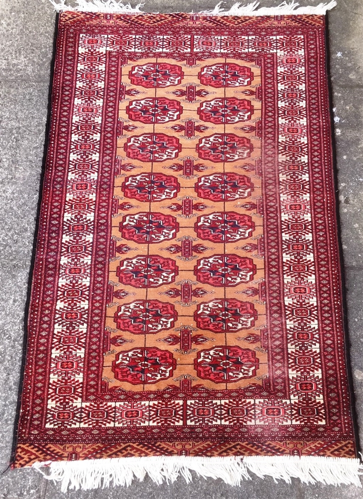 A RED GROUND RUG with two rows of guls, 145cm x 89cm