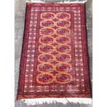 A RED GROUND RUG with two rows of guls, 145cm x 89cm