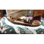 A DIORAMA OF A PETERHEAD FISHING BOAT ON A ROLLING SEA in a glazed mahogany case, overall 38cm high,