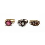 THREE MODERN GEM SET RINGS comprising; a 9ct gold and garnet seven stone gypsy-type ring, centred