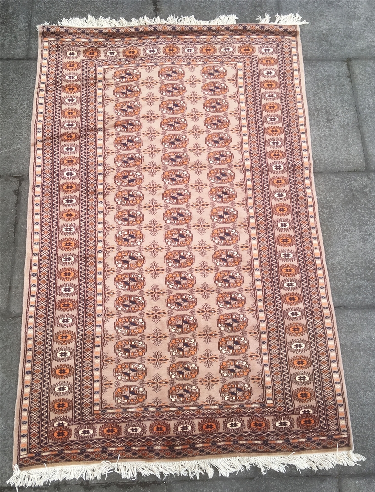 A RED GROUND RUG the central field with three rows of guls (faded), 200cm x 124cm