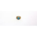 A MODERN CONTINENTAL TURQUOISE SINGLE STONE RING the oval cabochon claw set between open textured-