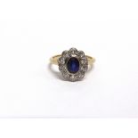 AN EARLY 20TH CENTURY GOLD, SAPPHIRE AND DIAMOND OVAL CLUSTER RING centred with an oval mixed-cut