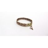 AN EARLY 20TH CENTURY ROSE GOLD HOLLOW WOVEN-WIRE HINGED BANGLE in Celtic style, on a push snap,