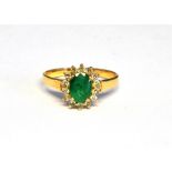 A MODERN EMERALD AND CUBIC ZIRCONIA OVAL CLUSTER RING centred with an oval mixed-cut emerald