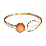 A MODERN 9CT GOLD AND SUNSTONE CABOCHON BANGLE the round high-dome cabochon approx. 12mm diameter,