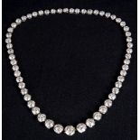 AN EARLY-MID 20TH CENTURY PLATINUM AND DIAMOND RIVIERE NECKLACE the 57 graduated old-cut &