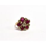 AN EARLY 20TH CENTURY GOLD, RUBY AND DIAMOND CLUSTER RING with a central old-cut diamond, approx.