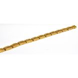 AN EARLY 20TH CENTURY GOLD PANEL BRACELET In the form 13reeded rectangular panels with raised floral