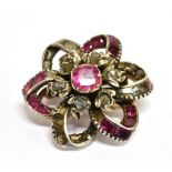 A RUBY AND DIAMOND FLOWER HEAD CLUSTER BROOCH IN VICTORIAN STYLE centred with a foil-backed